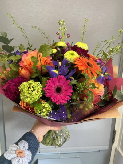 Vibrant Wishes - Bursting with vibrant colour and joyful energy, this hand-tied bouquet is designed to make a lasting impression. Featuring a lively blend of bright pink, orange, purple, green and cerise tones, it brings together striking textures and fresh seasonal foliage for a beautifully uplifting display.

Perfect for birthdays, congratulations, celebrations, thank-you gifts, or simply to brighten someone's day, this eye-catching arrangement radiates happiness, warmth and positivity. Expertly arranged and gift-wrapped, it arrives ready to delight any recipient.
