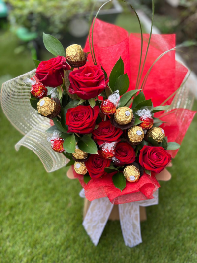 Sweet Love - A romantic gift arrangement that beautifully combines timeless elegance with a touch of luxury. Rich crimson tones are paired with premium chocolates and stylish greenery, creating a stunning display that is both thoughtful and indulgent. Wrapped in vibrant presentation materials and finished with a delicate ribbon, this eye-catching design is perfect for anniversaries, Valentine’s Day, romantic gestures, celebrations, or simply showing someone how much they mean to you. A wonderful combination of beauty and sweet treats that is sure to leave a lasting impression.