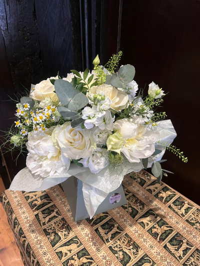 Pure Grace - An elegant all-white arrangement designed to convey sophistication, serenity and timeless beauty. Featuring a harmonious blend of soft textures, delicate seasonal accents and fresh foliage, this design creates a light and airy display with a refined, contemporary feel. Presented in a stylish keepsake container, it is a thoughtful choice for celebrations, sympathy gestures, weddings, anniversaries or any occasion where understated elegance speaks volumes. A truly graceful arrangement that brings a sense of calm and beauty to any setting.