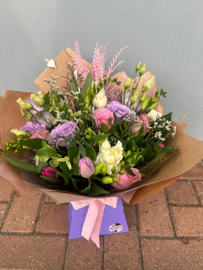 Pastel Dreams - A beautifully delicate arrangement featuring soft pink, lilac and ivory tones, thoughtfully combined with fresh greenery and airy seasonal accents. Designed to evoke elegance and serenity, this charming bouquet offers a graceful blend of colour, texture and natural beauty. Presented in stylish kraft wrapping with a coordinating gift bag and ribbon, it makes a wonderful choice for birthdays, new baby celebrations, thank-you gifts, anniversaries or simply sending a thoughtful message of love and appreciation. A timeless design full of gentle charm and sophistication.